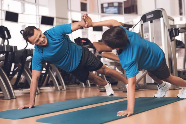 Papá e hijo con la misma ropa en el gimnasio. Padre e hijo llevan un estilo de vida saludable . — Foto de Stock