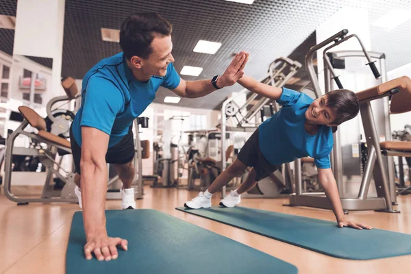 Papá e hijo con la misma ropa en el gimnasio. Padre e hijo llevan un estilo de vida saludable . — Foto de Stock