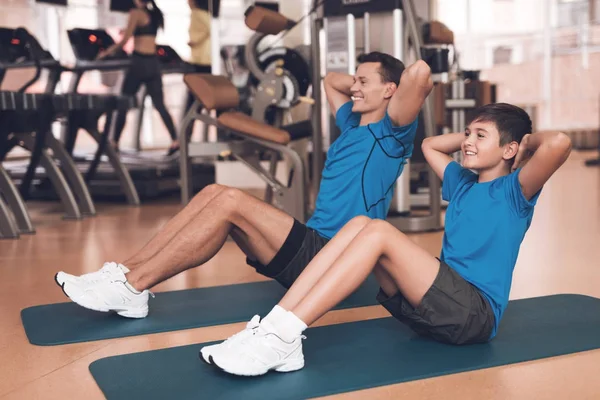 Papá e hijo con la misma ropa en el gimnasio. Padre e hijo llevan un estilo de vida saludable . — Foto de Stock