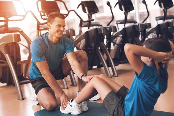 Dad and son in the same clothes in gym. Father and son lead a healthy lifestyle.