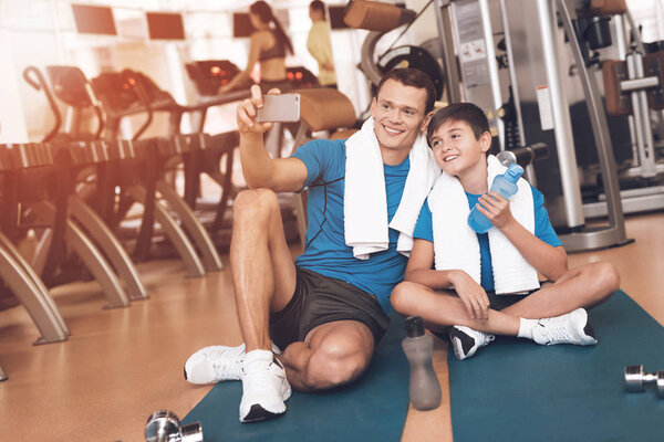 Dad and son in the same clothes in gym. Father and son lead a healthy lifestyle.