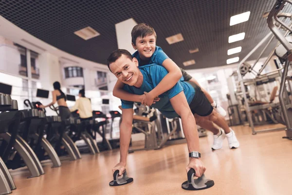 Pappa och son i samma kläder i gymmet. Far och son leda en hälsosam livsstil. — Stockfoto