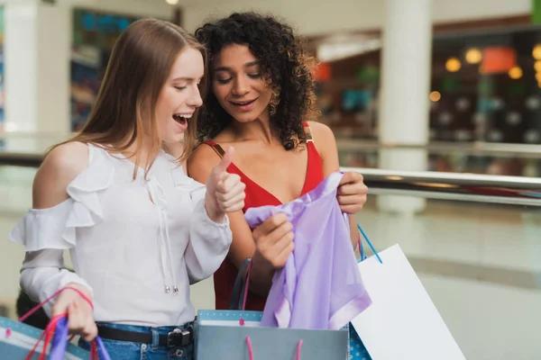 Las chicas están de compras en el centro comercial. Venta en Viernes Negro. Las niñas están de compras en un viernes negro . — Foto de Stock