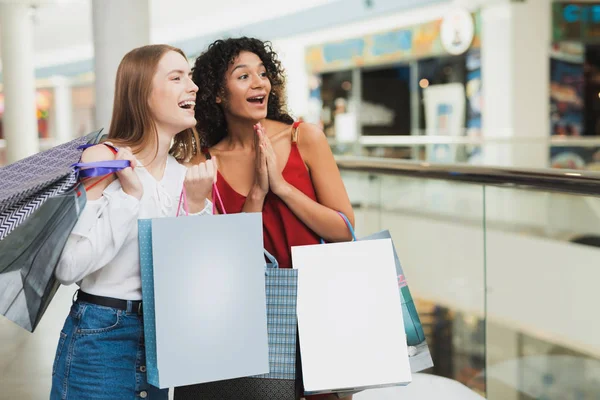 Las chicas están de compras en el centro comercial. Venta en Viernes Negro. Las niñas están de compras en un viernes negro . — Foto de Stock