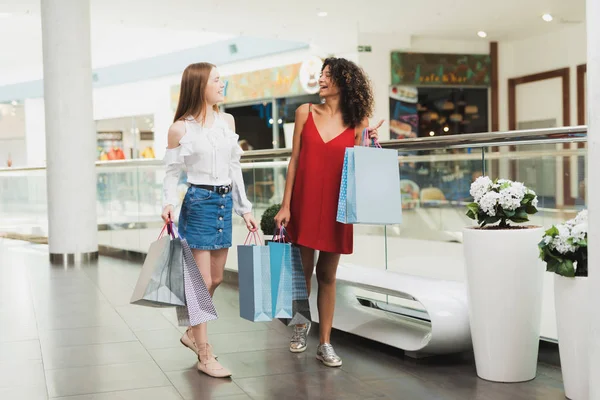 Las chicas están de compras en el centro comercial. Venta en Viernes Negro. Las niñas están de compras en un viernes negro . — Foto de Stock