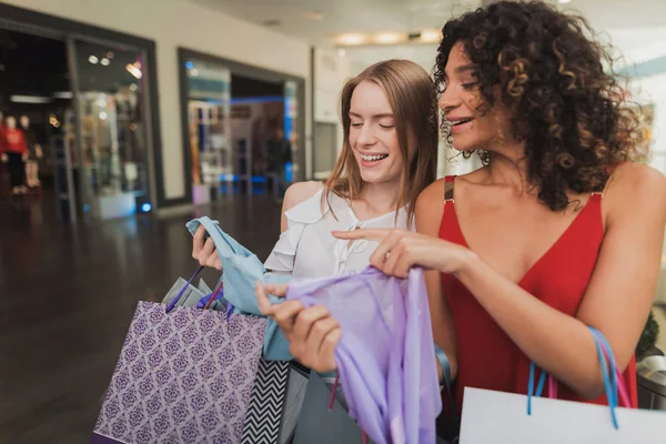 As raparigas estão a fazer compras no centro comercial. Venda na Black Friday. Meninas estão comprando em uma sexta-feira negra . — Fotografia de Stock