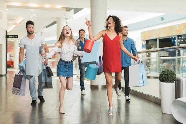 Vendita in Venerdì nero. La compagnia dei giovani è impegnata nello shopping in un venerdì nero . — Foto Stock