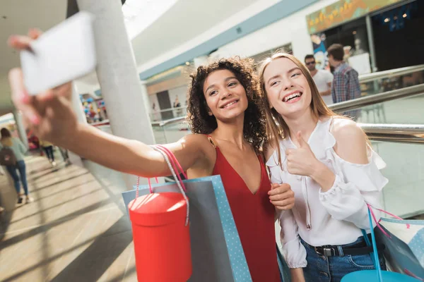 Las chicas están de compras en el centro comercial. Venta en Viernes Negro. Las niñas están de compras en un viernes negro . — Foto de Stock