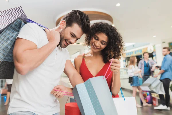 La chica y su novio están de compras en el centro comercial. Venta en un viernes negro. Una joven pareja está de compras . —  Fotos de Stock