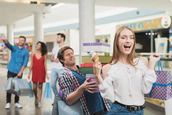 The girl and her boyfriend are shopping at the mall. Sale on a black Friday. A young couple are shopping. — Stock Photo, Image