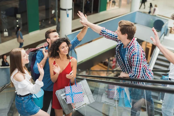 A young company met at the mall. They are on a shopping on a black Friday.