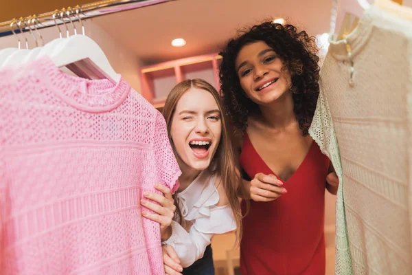Two beautiful girls have fun in the fitting room. They\'re shopping on a black Friday.