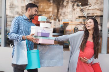 Vitrin çocuk mal ile geçmiş yürüyen bir adam hamile bir kadınla.