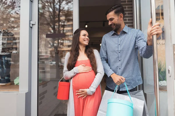 Un hombre y una mujer embarazada abandonan la tienda . — Foto de Stock