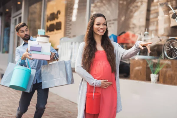 Vitrin çocuk mal ile geçmiş yürüyen bir adam hamile bir kadınla.