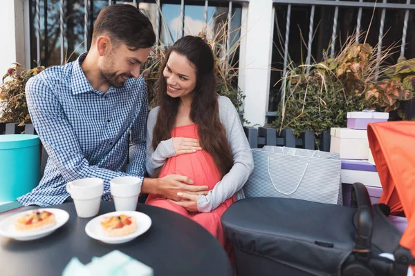 A pregnant woman with a man is sitting at a cafe table on the street. — Stock Photo, Image