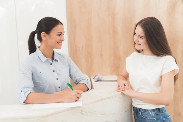 Mörkhåriga kvinnan arbetar i receptionen. Hon arbetar i en skönhetssalong. — Stockfoto