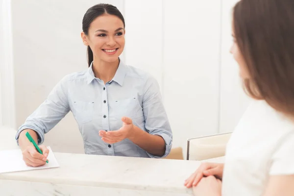 The dark-haired woman works at the reception. She works in a beauty salon. — Stock Photo, Image