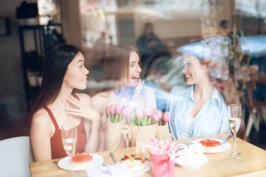 Üç kız birlikte bir kafede oturuyor.