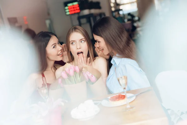 Tre flickor sitter tillsammans på ett café. — Stockfoto