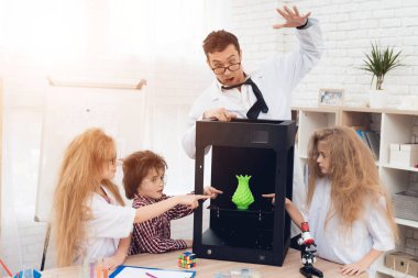 Çocuk bir öğretmen ile 3d bir yazıcıda farklı maddeleri yazdır.