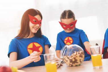 Süper kahramanlar kırmızı ve mavi elbiseli çocuk anne. Onlar maskeleri ve yağmurluklar.