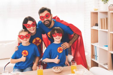 Young family in red and blue suits of superheroes. Their faces in masks and they are in raincoats. clipart