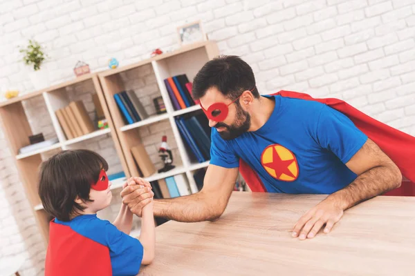 Padre e hijo con trajes de superhéroes. Compiten en la lucha libre. Ellos miden su fuerza — Foto de Stock