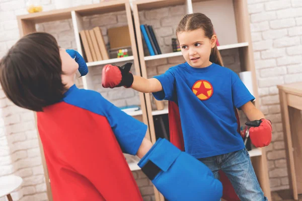 Dzieci w kolorach czerwonym i niebieskim superbohaterów. One w maskach. Pozowanie w jasny pokój dla dzieci. — Zdjęcie stockowe