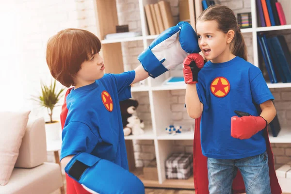 Dzieci w kolorach czerwonym i niebieskim superbohaterów. One w maskach. Pozowanie w jasny pokój dla dzieci. — Zdjęcie stockowe