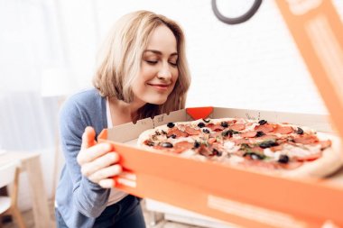 Kız evde pizza teslimi emretti. Pizza teslimat ile mutlu bir genç kadındır.