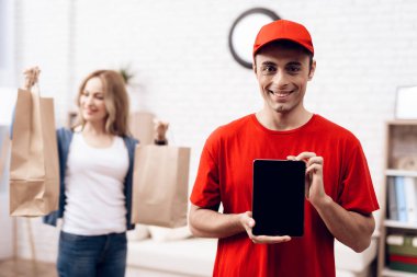 Bir adam Arap görünüm donatım teslimi çalışıyor. Adam bir tablet tutuyor.