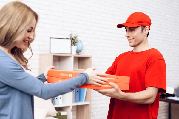 Man of Arab nationality works on the delivery of pizza. Pizza deliveryman brought an order to woman.