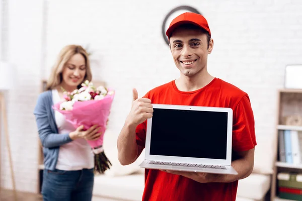 Man of Arab appearance works in the delivery of equipment. The man is holding a laptop in his hands.