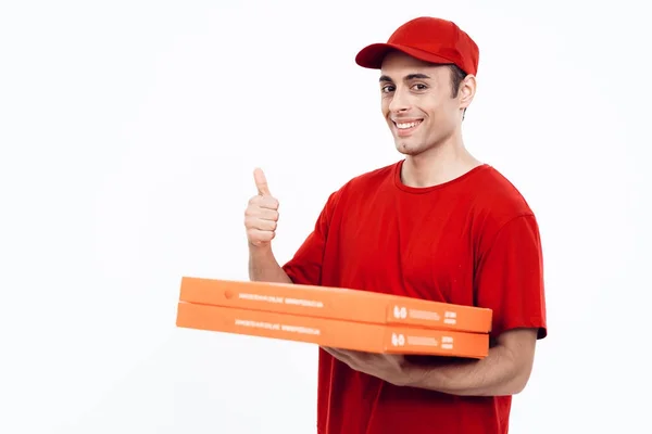 Uomo di aspetto arabo lavora nella consegna della pizza. L'uomo in uniforme rossa tiene una scatola di pizza. . — Foto Stock