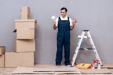 Adam Arap görünüm bir ressam olarak çalışıyor. Bir adam boyama duvarları var. Özel bir üniforma giydiği bildirildi.