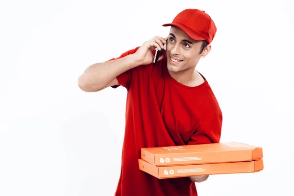 Uomo di aspetto arabo lavora nella consegna della pizza. L'uomo in uniforme rossa tiene una scatola di pizza. . — Foto Stock