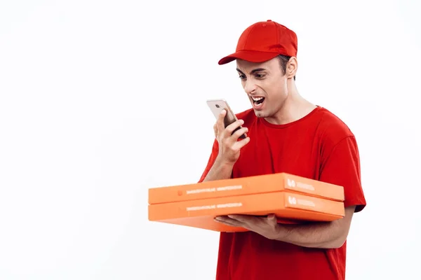 Man of Arab appearance works in the delivery of pizza. Man in red uniform is holding a box of pizza. — Stock Photo, Image