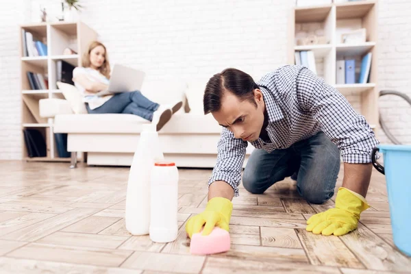 Un uomo che pulisce il pavimento nell'appartamento di una donna. Handyman sta pulendo l'appartamento — Foto Stock
