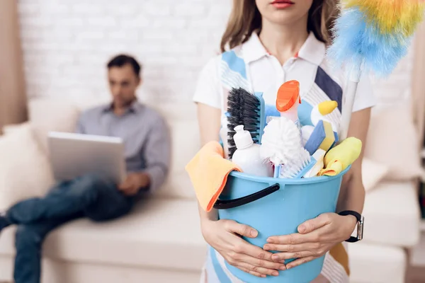 Limpador com acessórios para limpeza no apartamento de um homem. Uma mulher está limpando apartamento . — Fotografia de Stock