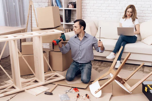 The man handyman is engaged in assembling the chair. The repairman is engaged in mending chair. — Stock Photo, Image