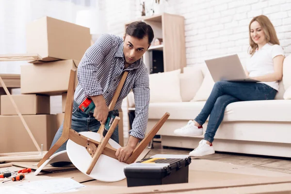 El hombre manitas se dedica a montar la silla. El reparador se dedica a reparar la silla . — Foto de Stock