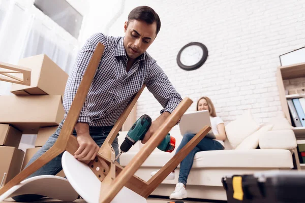 El hombre manitas se dedica a montar la silla. El reparador se dedica a reparar la silla . — Foto de Stock