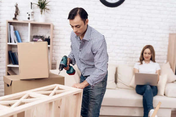 El manitas de hombre se ocupa del montaje de los muebles. Reparador se dedica a reparar muebles . — Foto de Stock