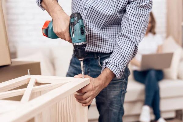 El manitas de hombre se ocupa del montaje de los muebles. Reparador se dedica a reparar muebles . — Foto de Stock