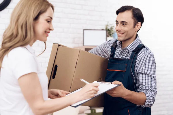 La mujer recibió el paquete del repartidor. El hombre cargador pasa las cajas a la mujer . —  Fotos de Stock