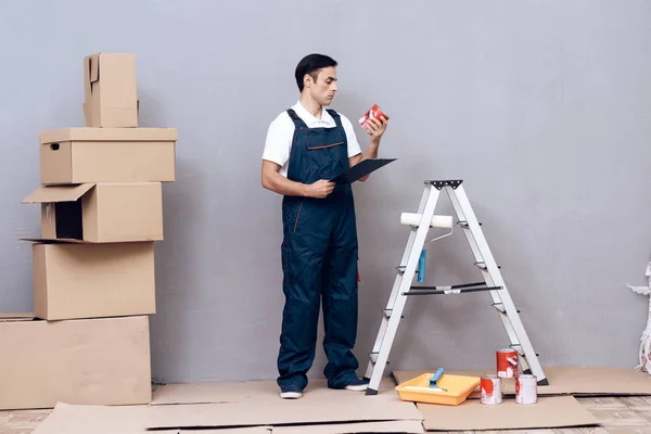 Hombre de apariencia árabe trabaja como pintor. Un hombre está pintando paredes. Lleva un uniforme especial. . — Foto de Stock