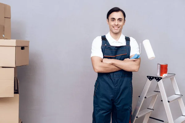 Man van Arabische verschijning werkt als schilder. Een man is schilderen muren. Hij draagt een speciaal uniform. — Stockfoto