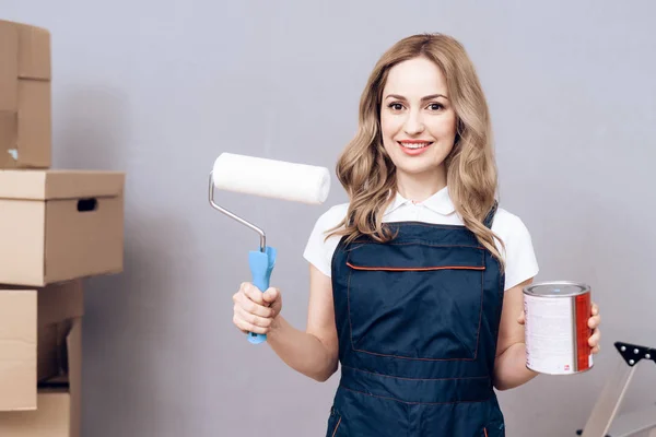 Una joven dirigiendo un pintor de casas. Una mujer se dedica a pintar las paredes . —  Fotos de Stock