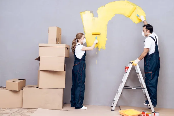 Eine junge Frau und ein Mann arabischen Aussehens arbeiten als Maler. eine Frau und ein Mann streichen Wände. — Stockfoto